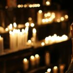 Hands clasped in prayer by candlelight in a church in São Paulo, Brazil, evoking a spiritual atmosphere.